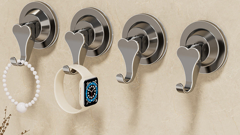 Four silver wall hooks on a beige wall with a black text box at the bottom.