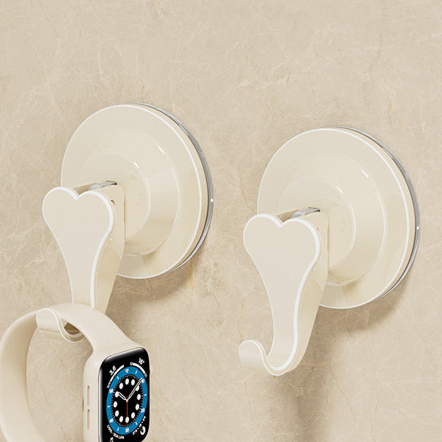 Two white suction cup hooks on a beige wall with an Apple Watch displayed.